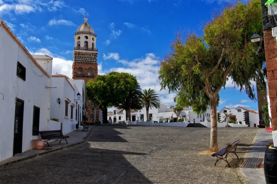 Place de Teguise, Lanzarote, avec des bâtiments blancs traditionnels et des rues pavées.