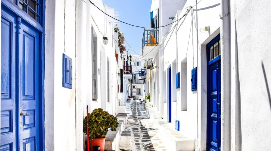 Rue étroite avec porte bleue à Mykonos, Grèce