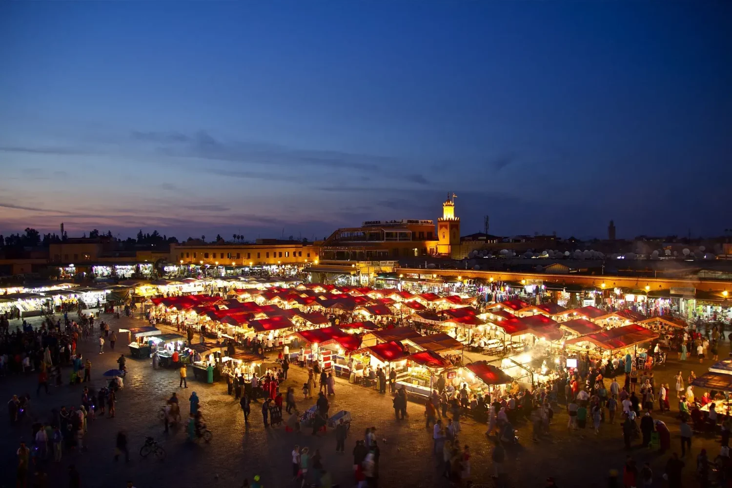 Place Jemaa el-Fna de nuit à Marrakech, vue générale avec foule, lumières et étals de nourriture.