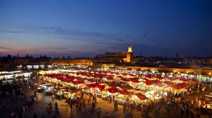 Place Jemaa el-Fna de nuit à Marrakech, vue générale avec foule, lumières et étals de nourriture.