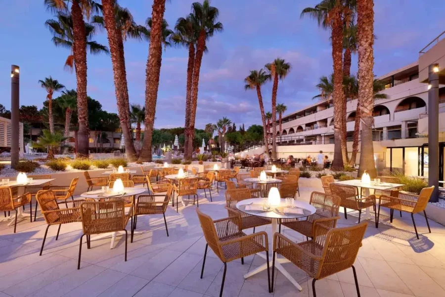 Restaurant extérieur du Grand Palladium Sicilia Resort & Spa en Italie, avec vue sur la piscine et les jardins.