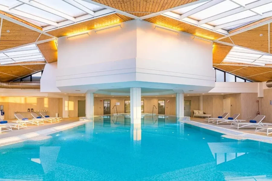 Spa du Grand Palladium Sicilia Resort & Spa en Italie, avec piscine intérieure et jets d'eau.